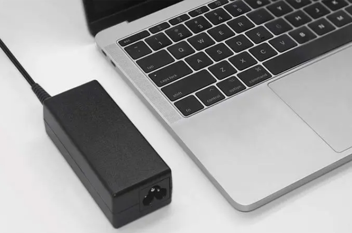 Why is the laptop power adapter not integrated into the laptop body?